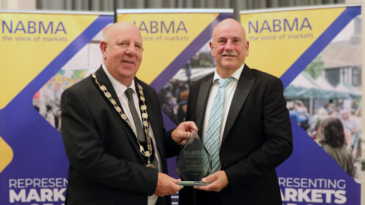 Councillor David Hopkins, President of NABMA, left, presents the Krys Zasada Award to Colin Wolstenholme, right.